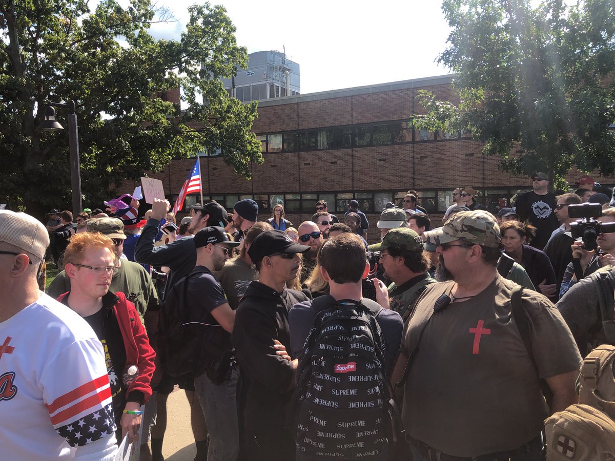 Kaitlin Bennett is   surrounded by militia members. Things are tense   so the policemen have a phalanx of riot policemen and Bennett has her personal guards.   